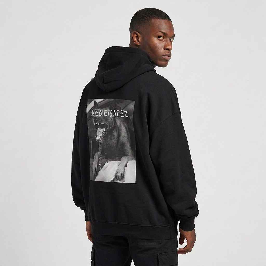 A man wearing a black oversized hoodie from the back, featuring a large black-and-white graphic print of a Belgian Malinois with the text 'RENEGADEZ' on the back, photographed against a light gray studio background.