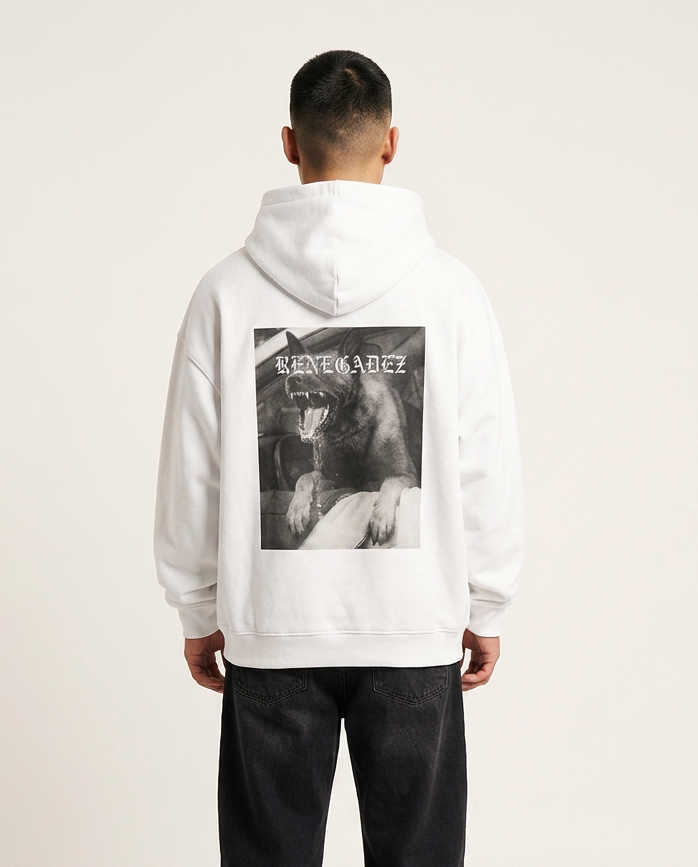 A man viewed from behind wearing a white pullover hoodie with a large black-and-white graphic print on the back, paired with loose black pants, against a plain light studio background.